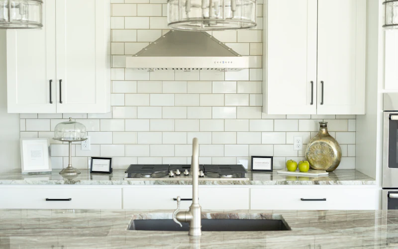 Clean white kitchen with clear counters and a tidy sink